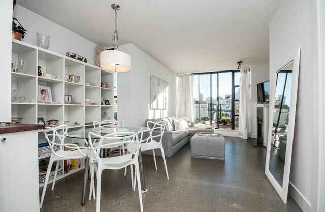 Spacious open-concept living room with modern white furniture, large windows, and a city view. - 312 - 1630 West 1st Ave., Vancouver West Side