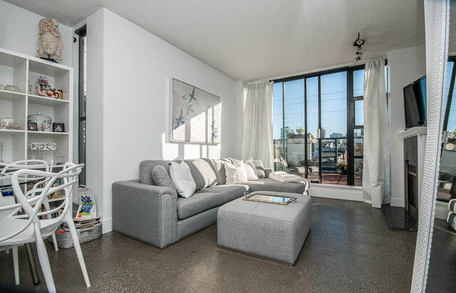 Spacious living room with modern sectional sofa, large windows, and city view. - 312 - 1630 West 1st Ave., Vancouver West Side