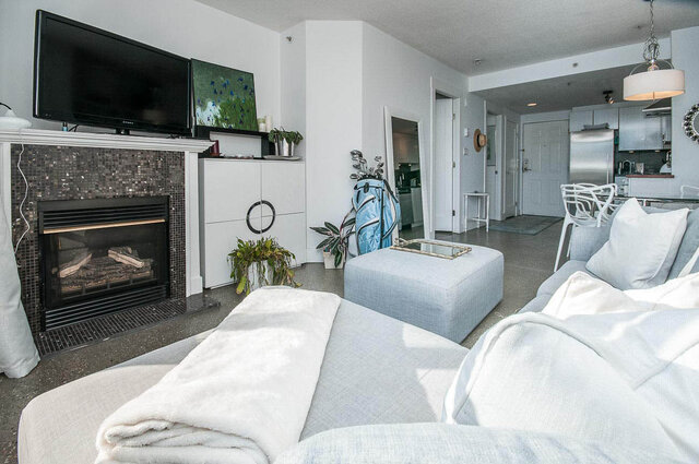 Spacious living room with a gas fireplace, modern TV, and a cozy sectional sofa. - 312 - 1630 West 1st Ave., Vancouver West Side