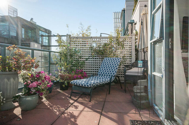 Furnished patio with outdoor seating, potted flowers, and city views. - 312 - 1630 West 1st Ave., Vancouver West Side