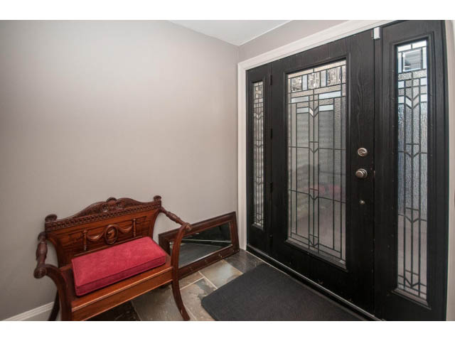 Foyer with ornate bench and black double doors with glass panels. - 14 West 13th Ave, Vancouver East Side