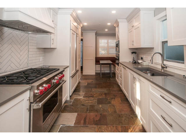 Bright kitchen with white cabinets, granite countertops, and a gas stove. - 14 West 13th Ave, Vancouver East Side