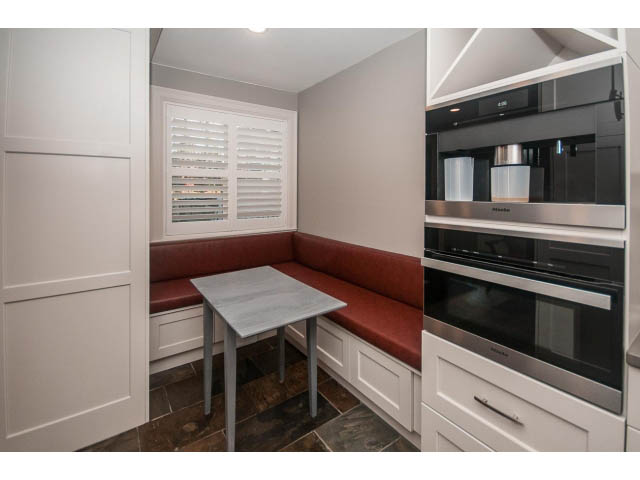 Bright kitchen with modern appliances and red cushioned seating. - 14 West 13th Ave, Vancouver East Side