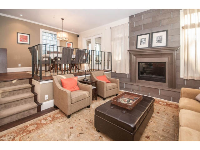 Spacious living room with fireplace, modern furniture, and large windows. - 14 West 13th Ave, Vancouver East Side