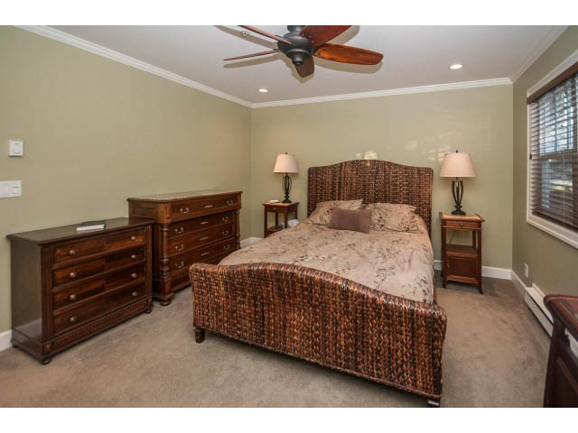 Spacious bedroom with wicker furniture, two lamps, and a ceiling fan. - 14 West 13th Ave, Vancouver East Side