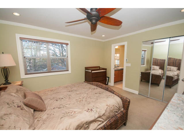 Spacious bedroom with large bed, patterned bedding, and mirrored closet. - 14 West 13th Ave, Vancouver East Side