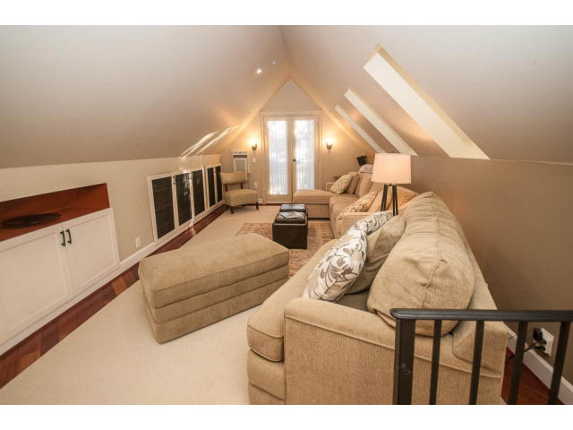 Spacious attic living room with hardwood floors and a cozy sectional sofa. - 14 West 13th Ave, Vancouver East Side