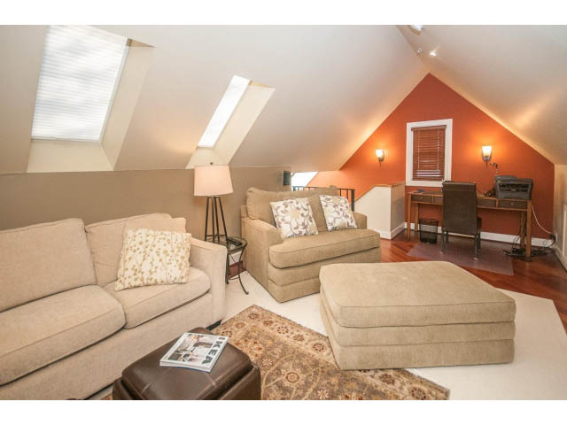Bright living room with hardwood floors and a cozy corner setup. - 14 West 13th Ave, Vancouver East Side