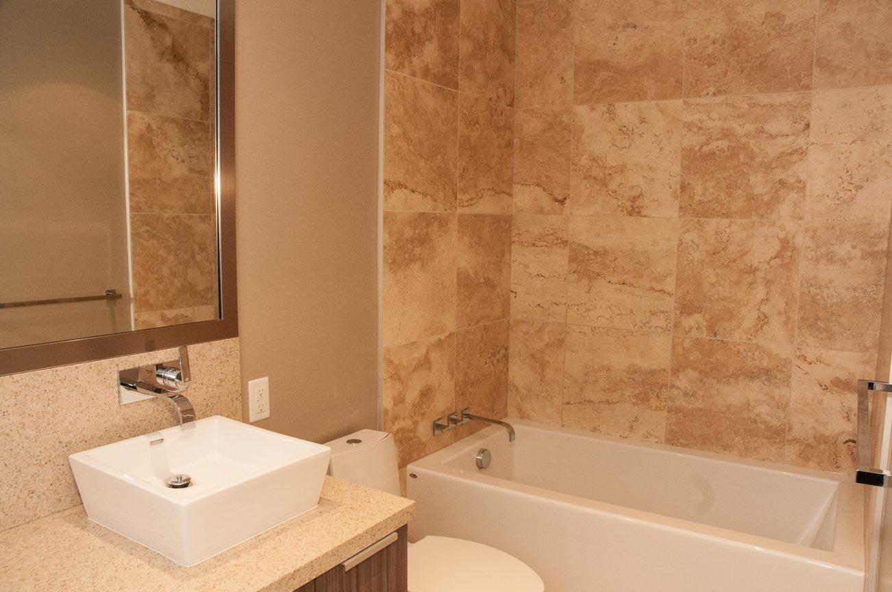 Bathroom with marble tiles and modern sink setup. - 1010-181 West 1st Avenue, Vancouver West Side