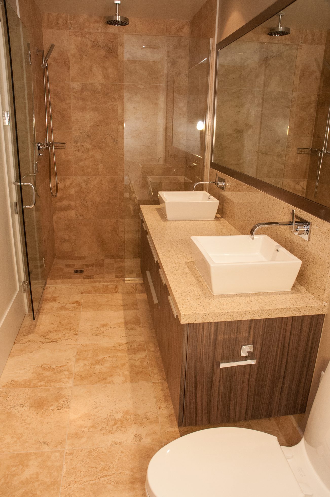 Furnished bathroom with dual sinks, marble countertops, and a walk-in shower. - 1010-181 West 1st Avenue, Vancouver West Side