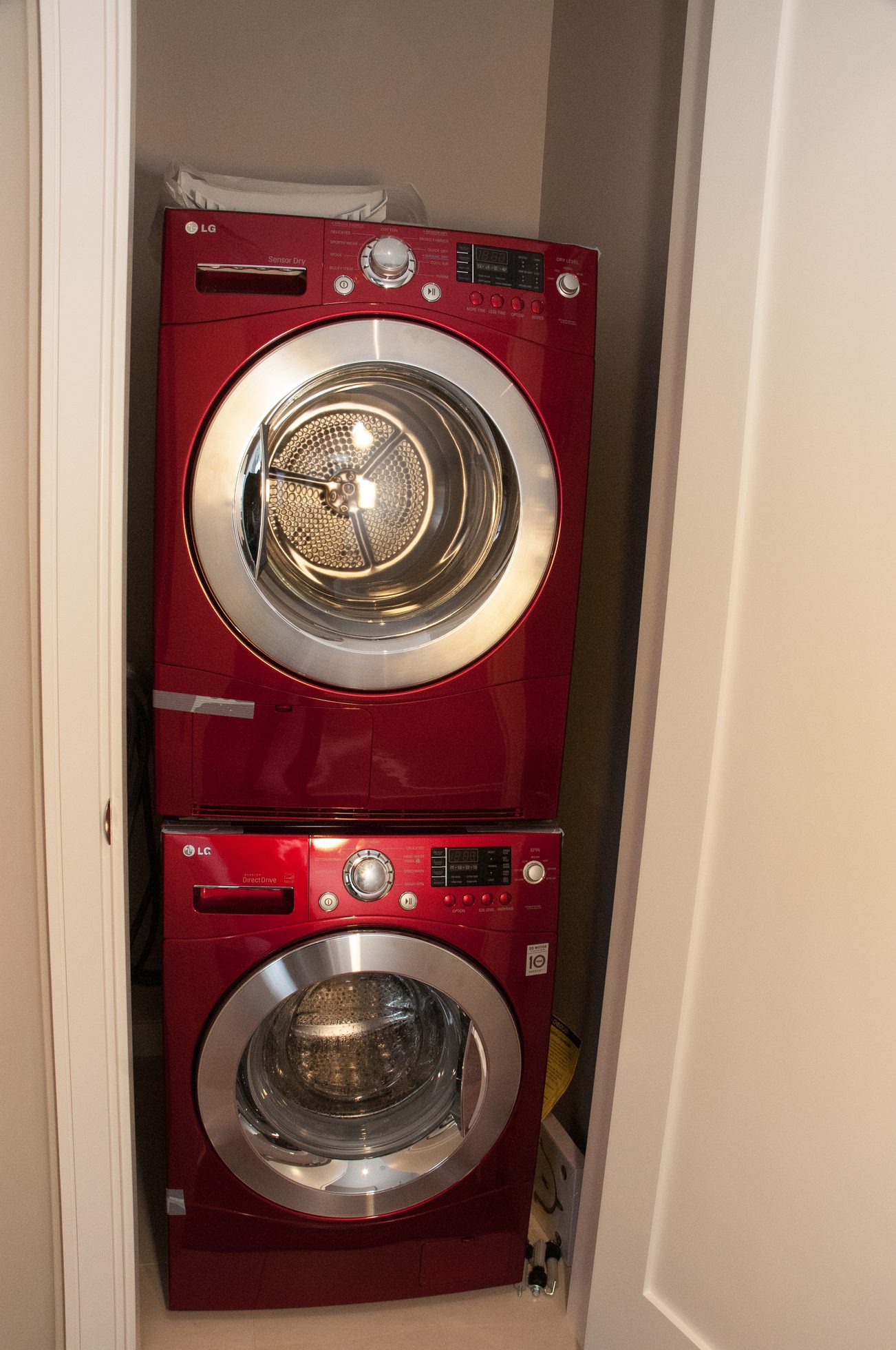 Bright laundry room with red stacked washer and dryer, clean and organized. - 1010-181 West 1st Avenue, Vancouver West Side