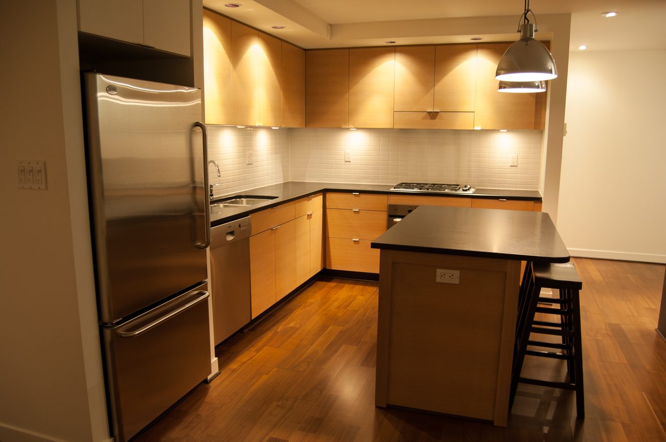 Bright kitchen with stainless steel appliances, hardwood floors, and a central island. - 1901-1055 Homer Street, Vancouver Downtown