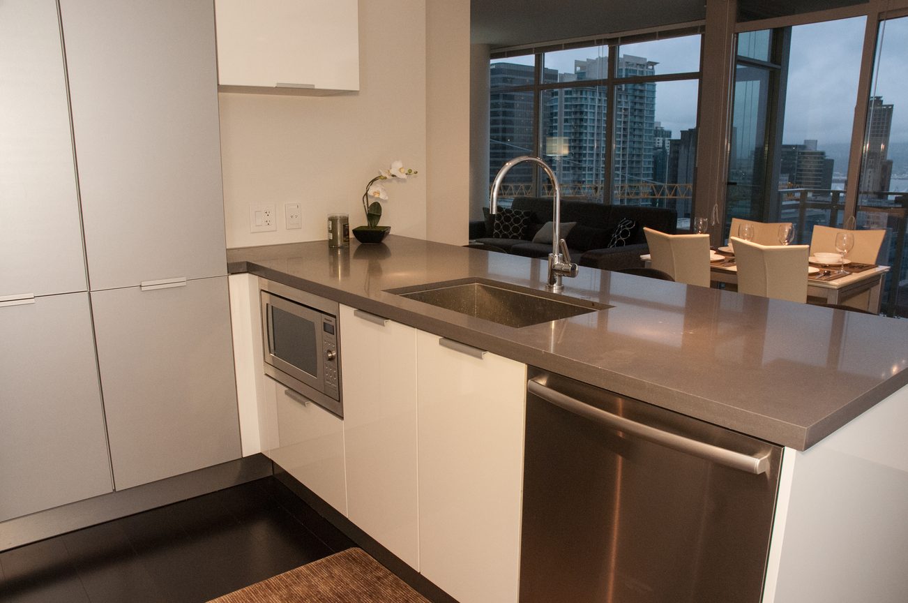 Bright kitchen with modern stainless steel appliances, sleek countertops, and a city view. - 2306-788 Richards, Vancouver Downtown
