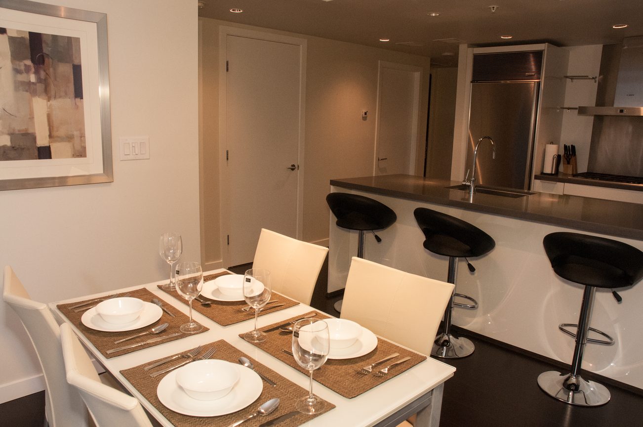 Modern dining area with sleek bar stools and stainless steel countertops. - 2306-788 Richards, Vancouver Downtown