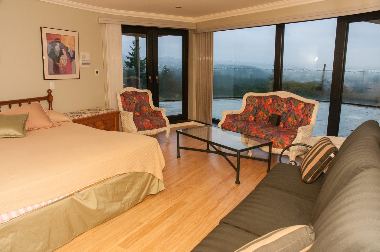 Bright living room with hardwood floors, large windows, and a cozy seating area. - 829 Younette Drive, West Vancouver