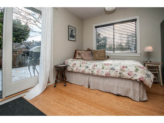 Bright living room with floral couch, hardwood floors, and a city view through the window. - Upper - 4838 Dunbar Street, Vancouver West Side