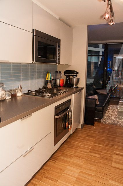 Bright kitchen with stainless steel countertops, hardwood floors, and a city view. - 506-128 West Cordova St, Vancouver Downtown