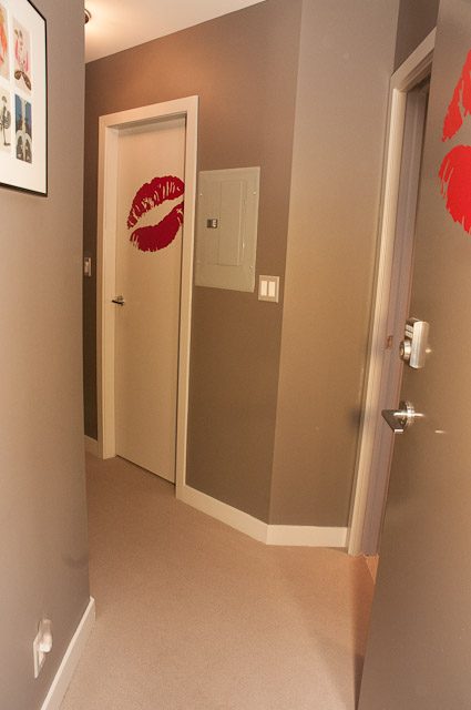 Furnished hallway with red lipstick kiss mark on door, neutral tones. - 506-128 West Cordova St, Vancouver Downtown