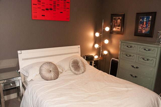 Furnished 2-bedroom condo with modern decor, white bedding, and a stylish lamp. - 506-128 West Cordova St, Vancouver Downtown