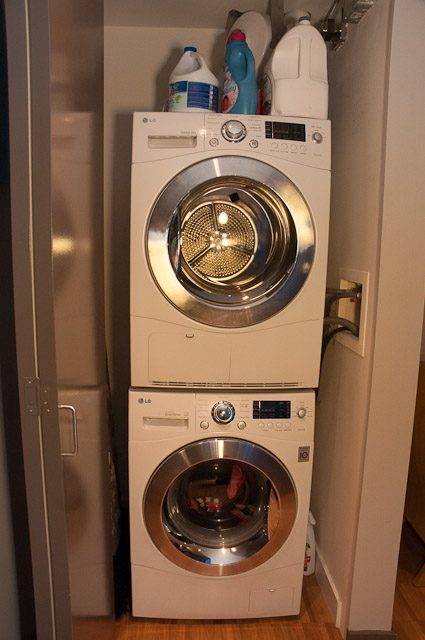 Bright laundry room with stacked washer and dryer, hardwood floors. - 506-128 West Cordova St, Vancouver Downtown