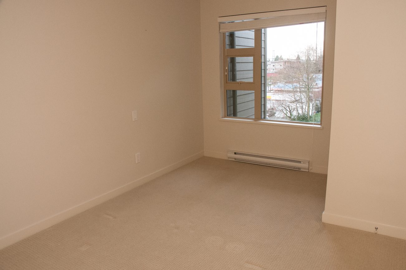 Bright bedroom with carpeted floor and city view. - 507-1677 Lloyd Avenue, North Vancouver