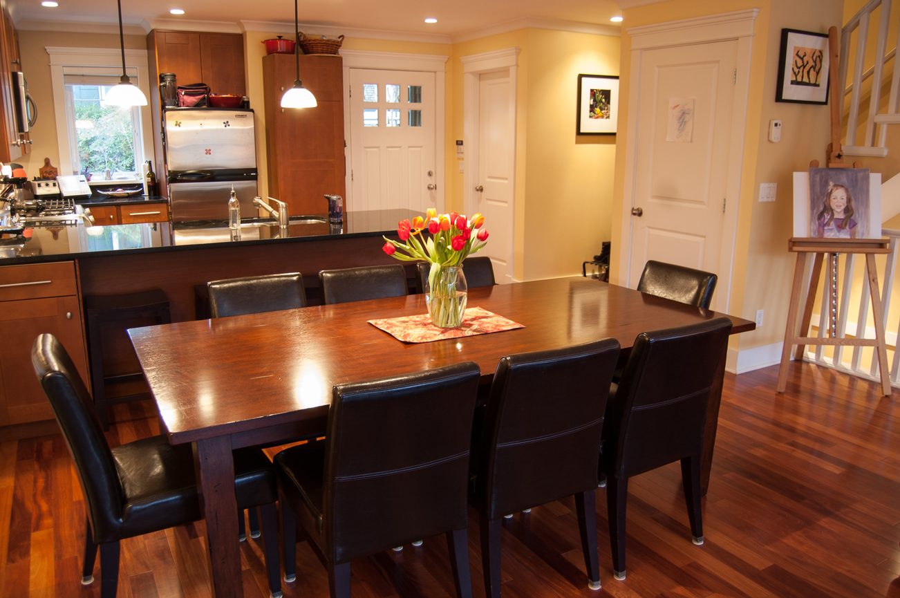 Furnished dining area with dark wood table, leather chairs, and hardwood floors. - 221 East 17th Street, North Vancouver