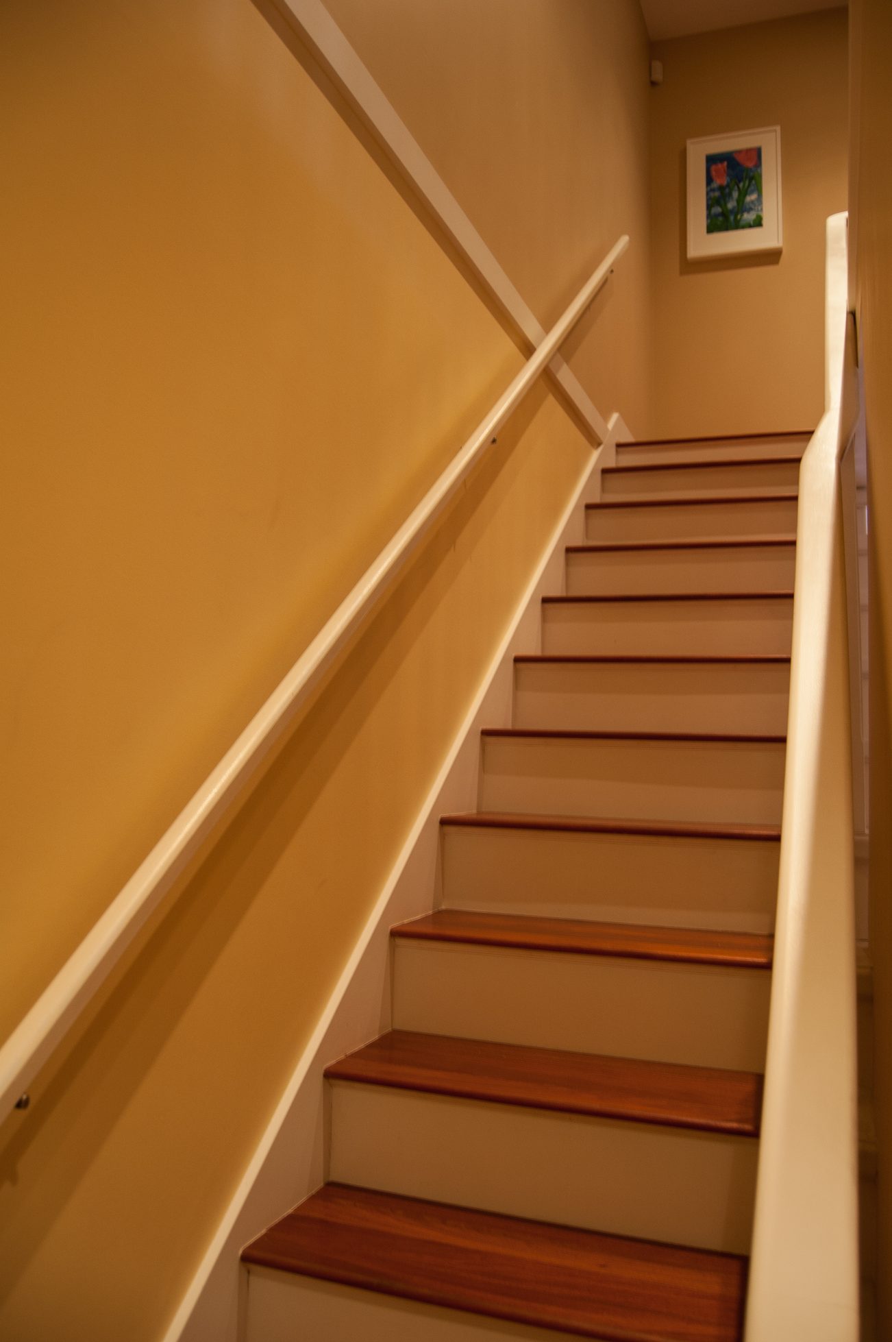Staircase leading to upper level with wooden steps and white railings. - 221 East 17th Street, North Vancouver