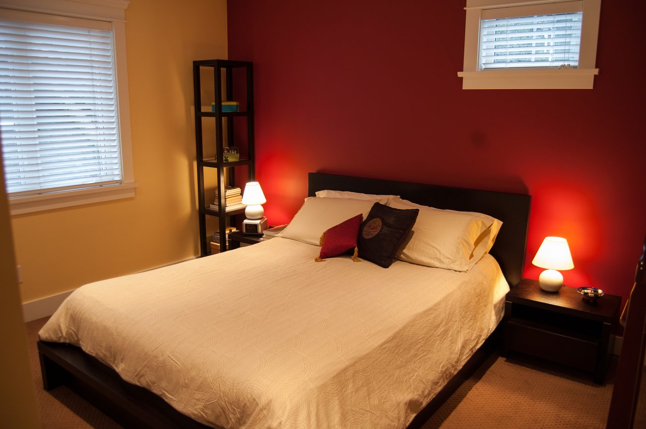 Spacious bedroom with red accent wall and cozy lighting. - 221 East 17th Street, North Vancouver