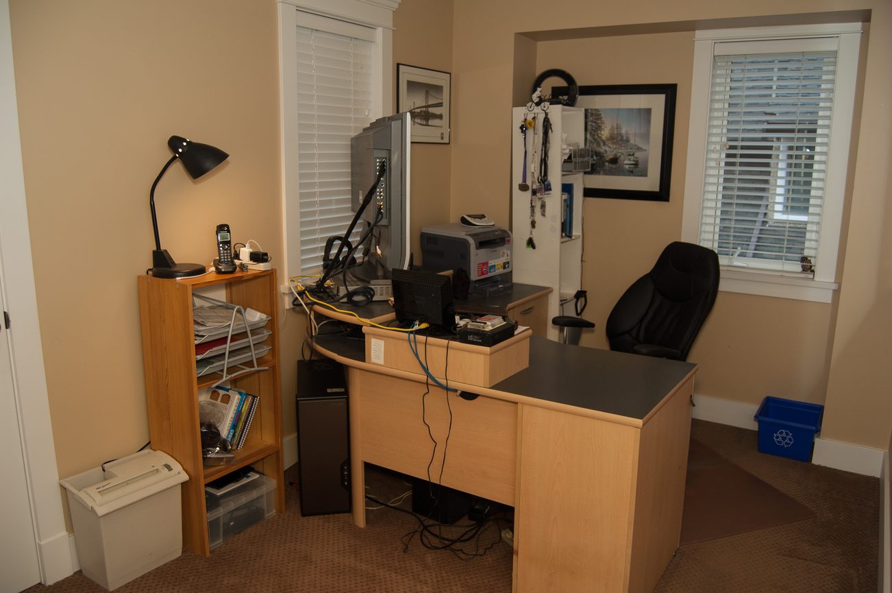 Furnished home office with wooden desk, computer, and office chair. - 221 East 17th Street, North Vancouver
