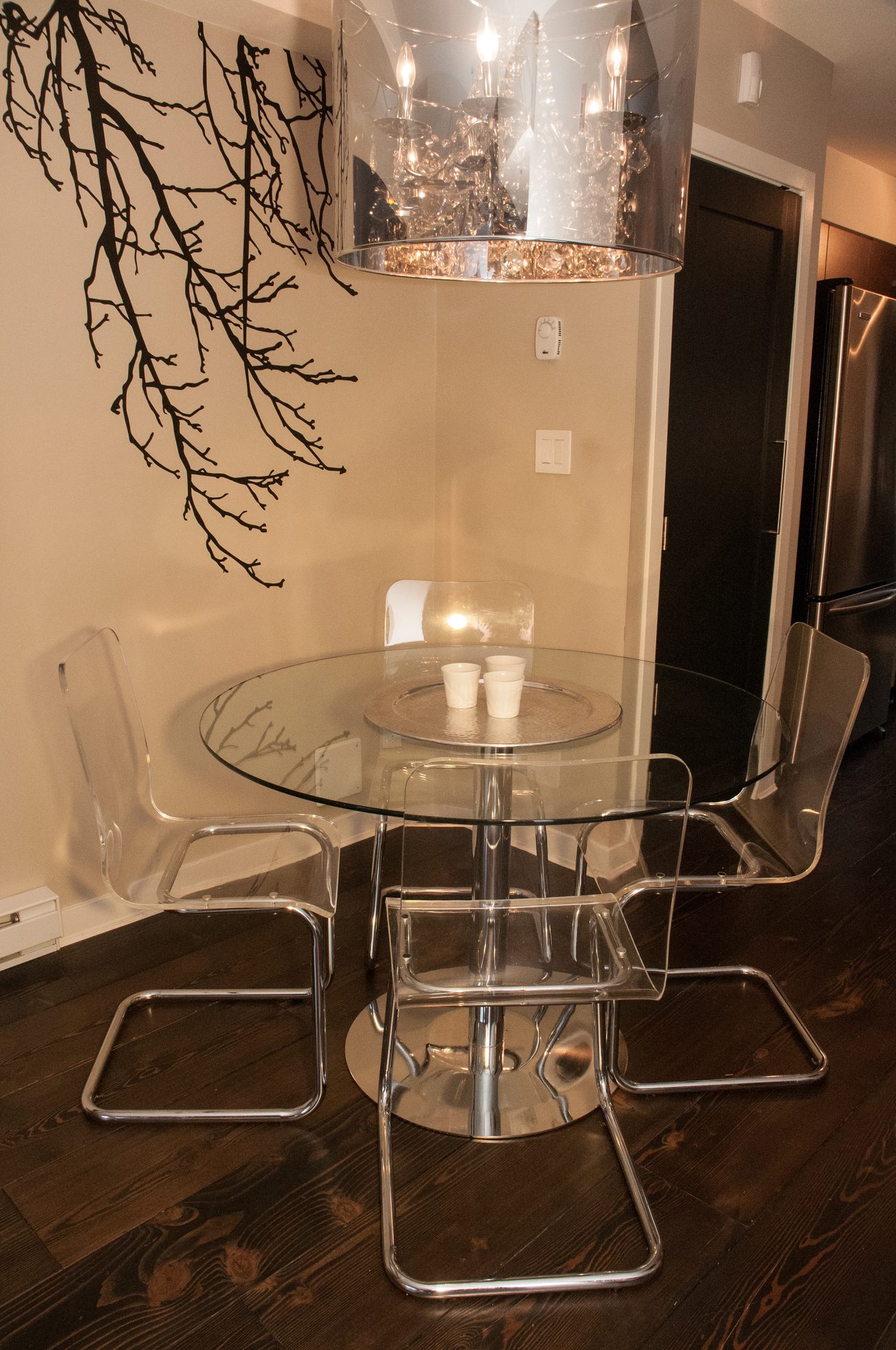 Bright dining area with clear acrylic chairs and a glass table, modern decor, hardwood floors. - 125- 1863 Stainsbury Ave, Vancouver West Side