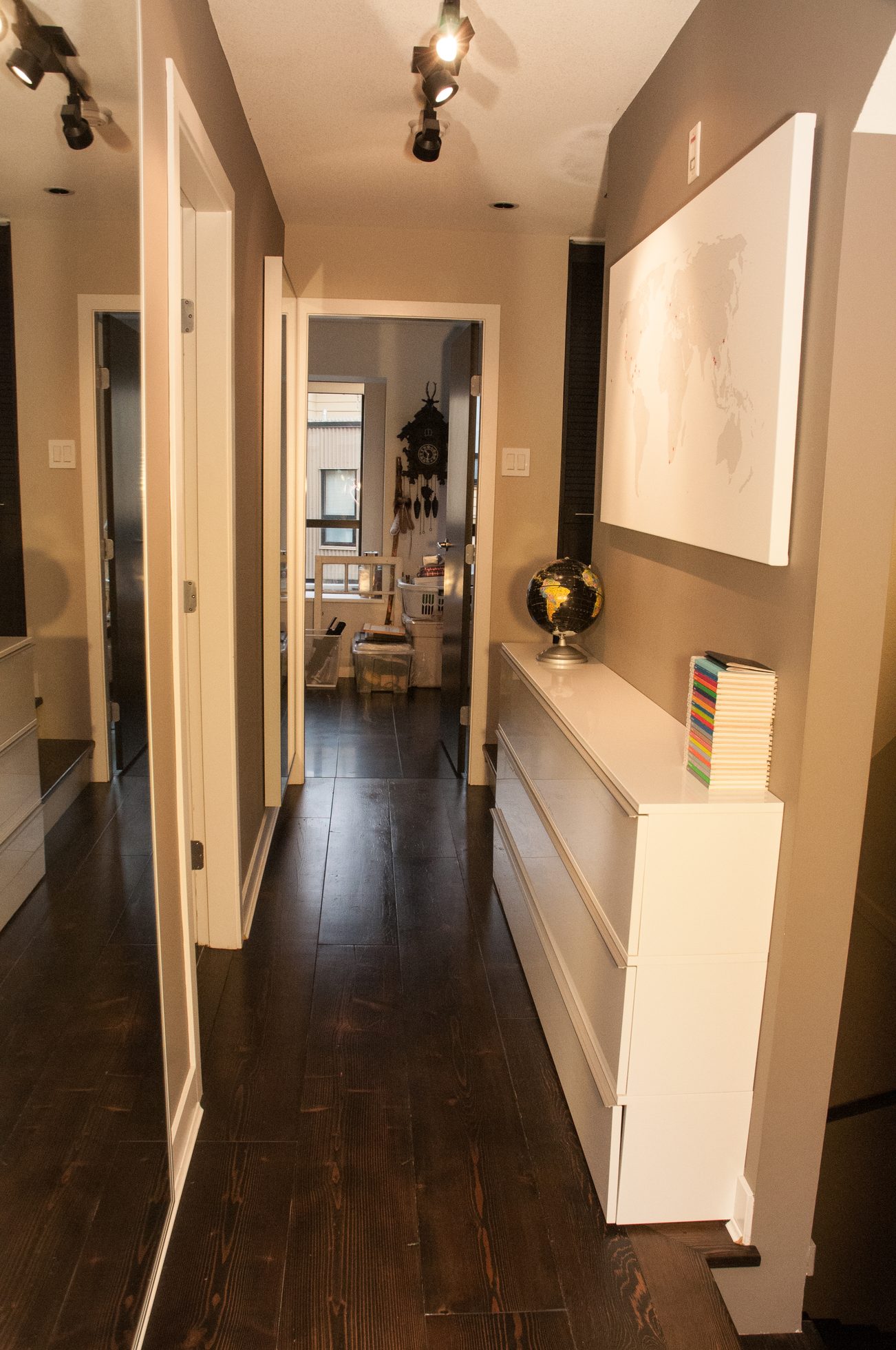 Foyer with dark hardwood floors, white cabinets, and a world map on the wall. - 125- 1863 Stainsbury Ave, Vancouver West Side