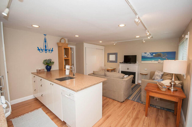 Open-concept living space with granite countertops and hardwood floors, perfect for a cozy North Vancouver retreat.