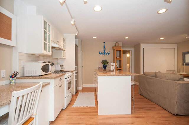 Bright kitchen with granite countertops and hardwood floors, leading to a cozy living area. - Address WITHHELD, North Vancouver