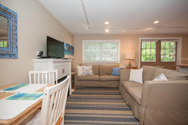 Spacious living room with striped furniture, large windows, and a cozy fireplace. - Address WITHHELD, North Vancouver