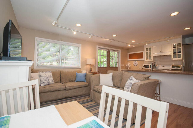 Spacious living room with a sectional sofa, hardwood floors, and a kitchen counter in the background. - Address WITHHELD, North Vancouver