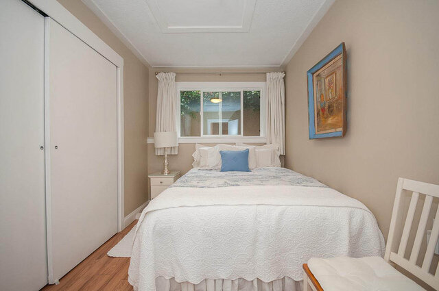 Spacious 1-bedroom furnished room with hardwood floors, a cozy bed, and a window view. - Address WITHHELD, North Vancouver