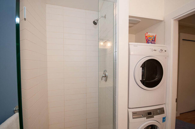 Compact bathroom with glass shower and stacked washer/dryer. - Address WITHHELD, North Vancouver