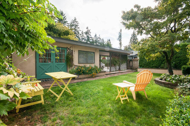 Spacious backyard with vibrant yellow Adirondack chairs and a cozy patio area. - Address WITHHELD, North Vancouver