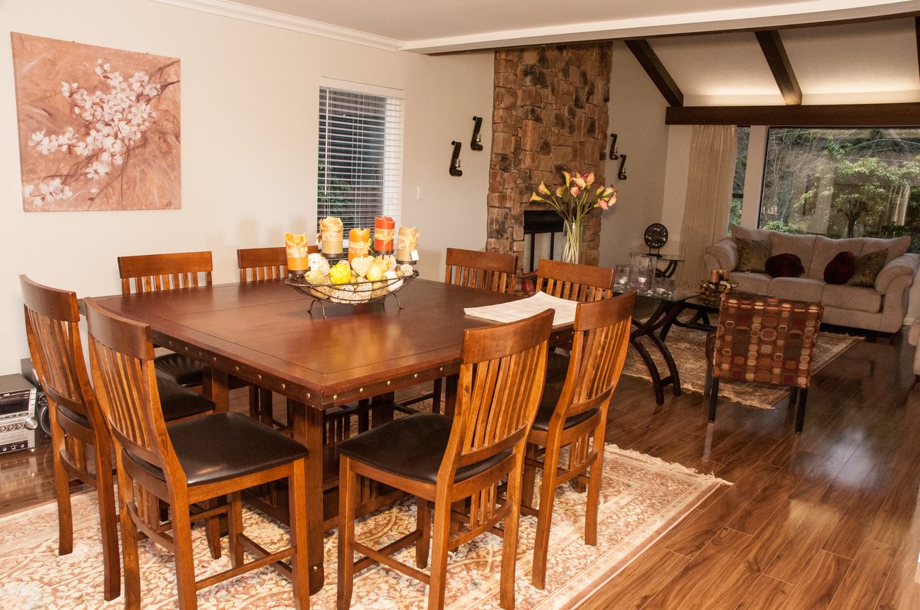 Dining room with wooden table, chairs, and stone fireplace. - 5550 Huckleberry Lane, North Vancouver