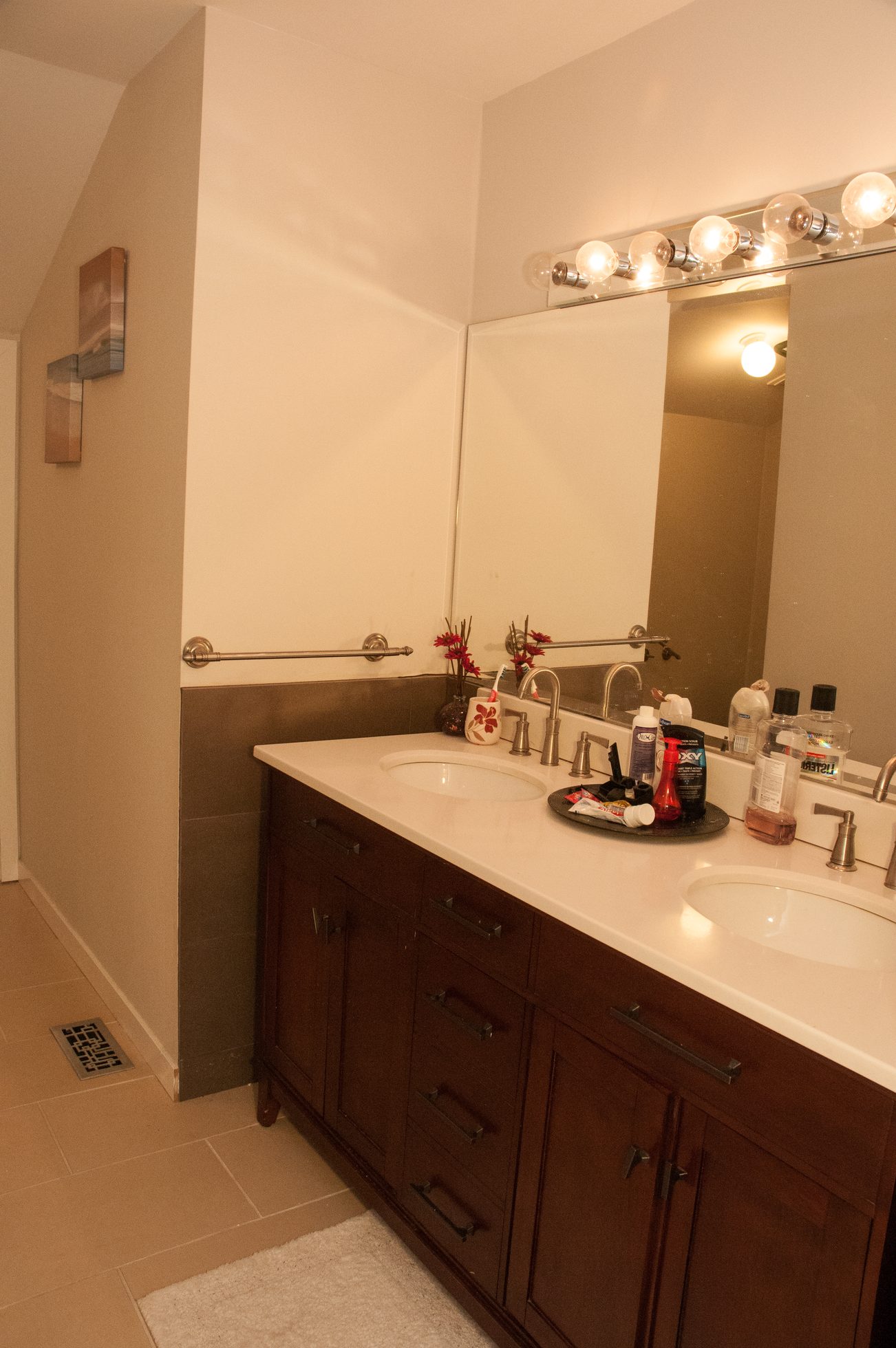 Bathroom with dark wood cabinets, white countertop, and decorative mirror lights. - 5550 Huckleberry Lane, North Vancouver