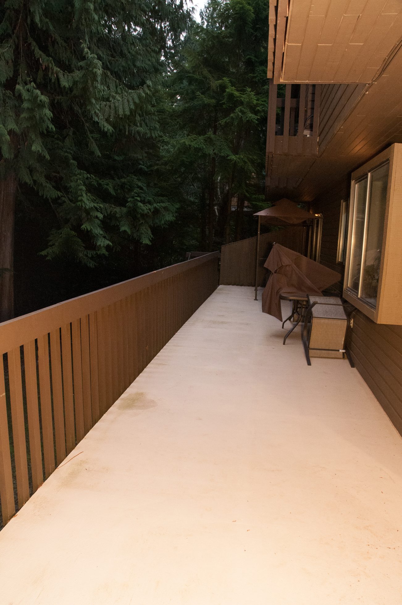 Furnished patio with wooden railings and forest view. - 5550 Huckleberry Lane, North Vancouver