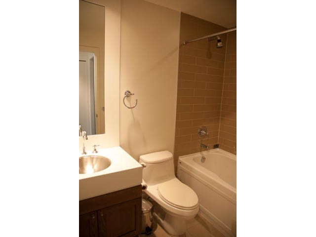 Bright bathroom with white sink, toilet, and bathtub, clean and organized. - 1501-1483 Homer Street, Vancouver Downtown