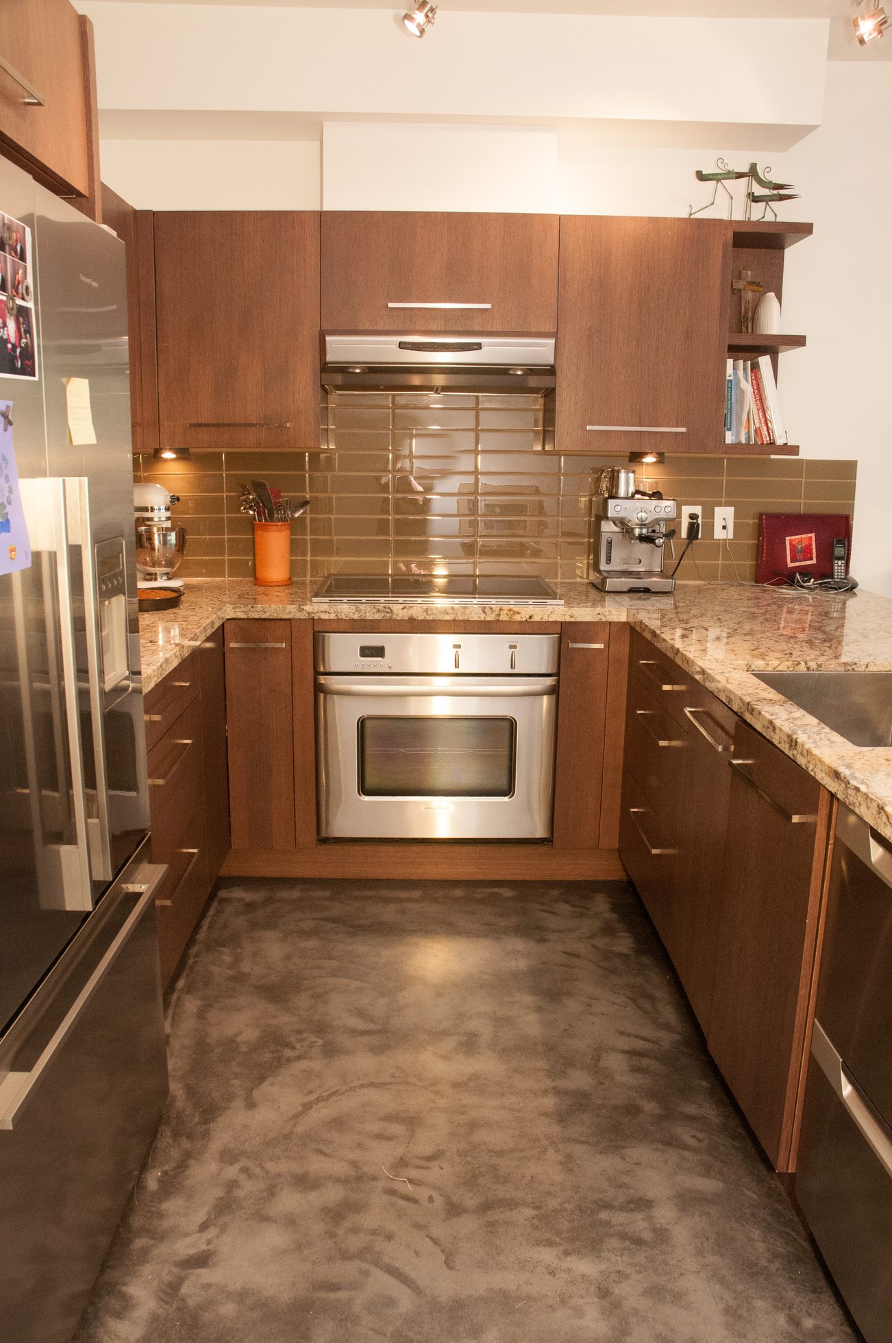 Bright kitchen with granite countertops, stainless steel appliances, and a concrete floor. - 306-650 Evergreen Place, North Vancouver