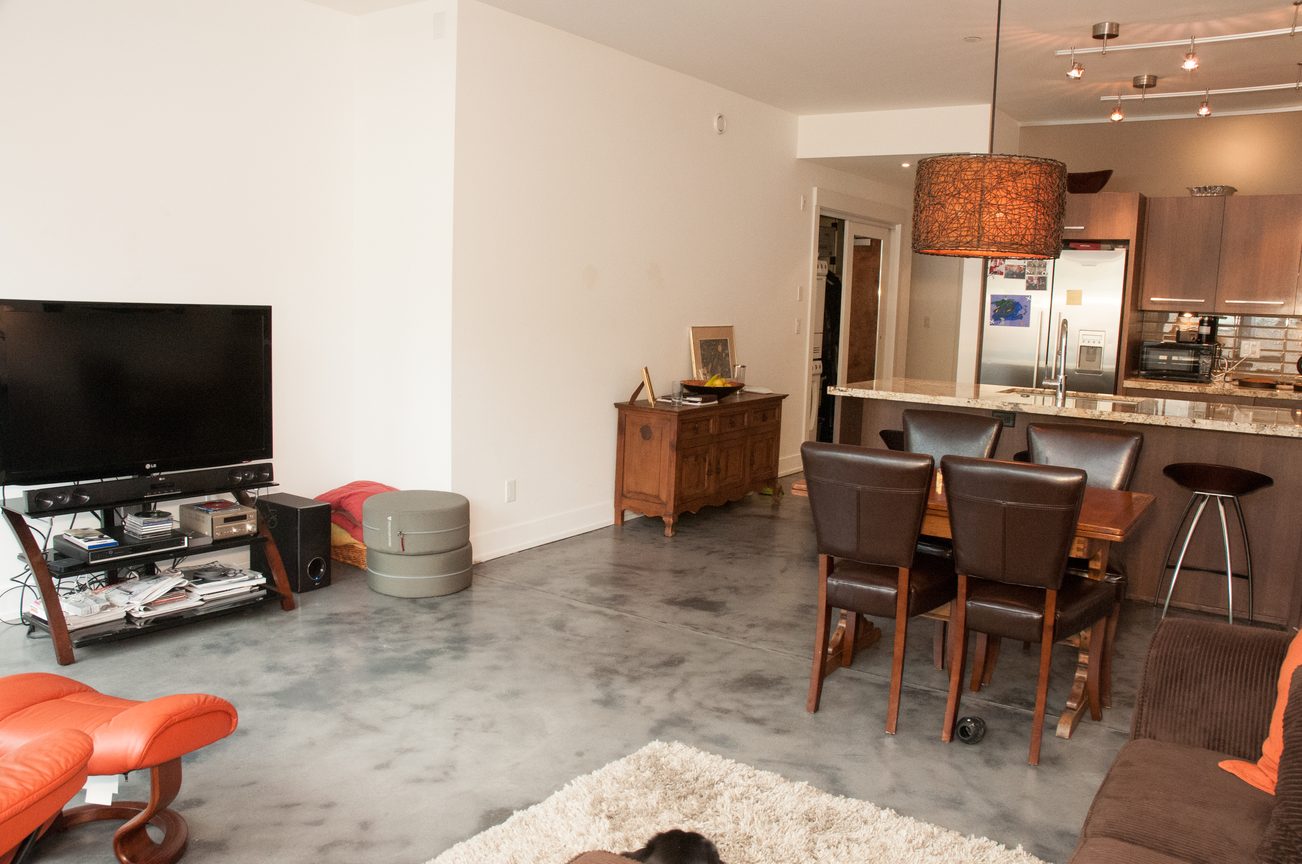 Open-concept living space with modern furnishings, granite countertops, and a cozy ambiance. - 306-650 Evergreen Place, North Vancouver