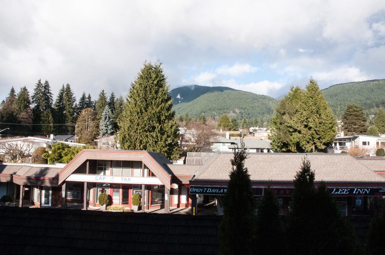Bright kitchen with city view and mountain backdrop, furnished. - 306-650 Evergreen Place, North Vancouver