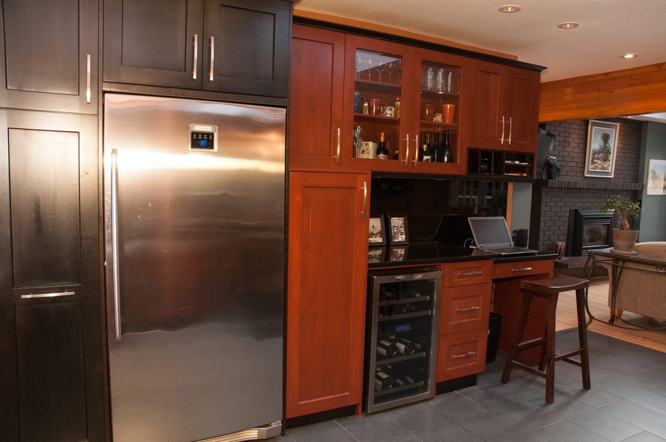 Bright kitchen with modern stainless steel fridge, dark wood cabinets, and black countertops. - 5646 Westport Rd, West Vancouver