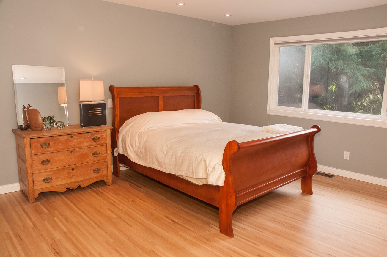 Spacious bedroom with hardwood floors and a large window. - 5646 Westport Rd, West Vancouver