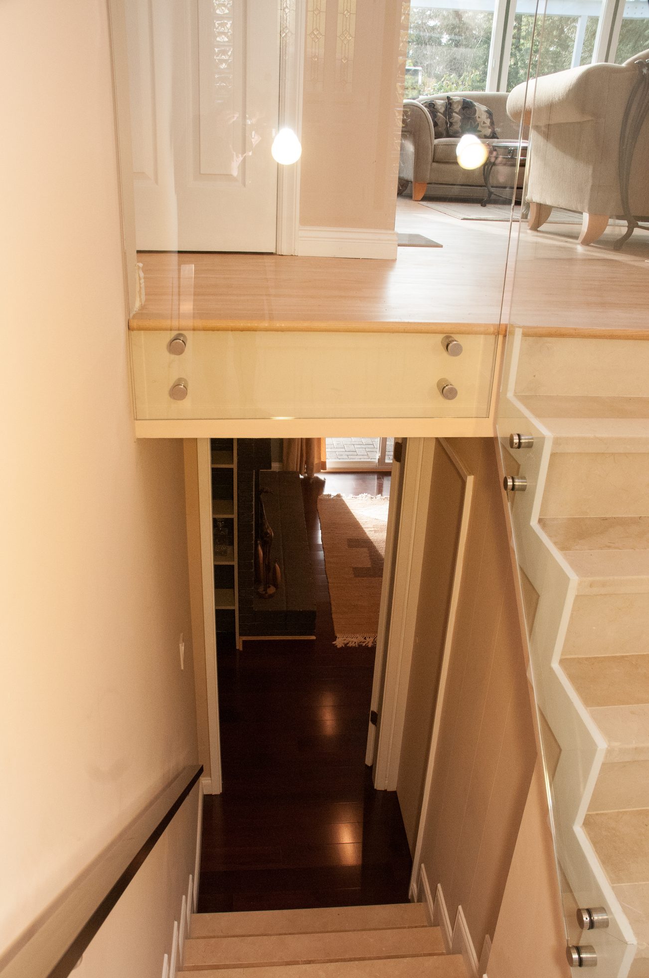 Staircase leading to a cozy living area with hardwood floors and a fireplace. - 5646 Westport Rd, West Vancouver