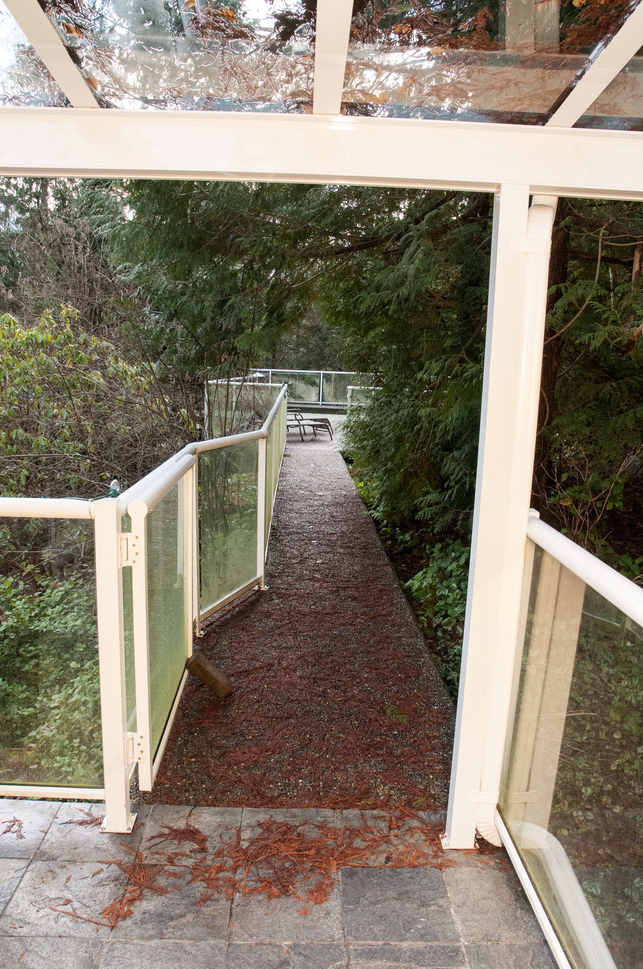 Furnished patio with glass railings and forest view. - 5646 Westport Rd, West Vancouver