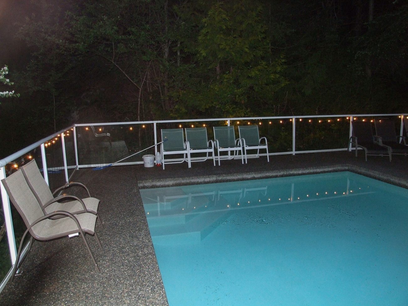 Furnished patio with a hot tub and string lights, surrounded by trees. - 5646 Westport Rd, West Vancouver